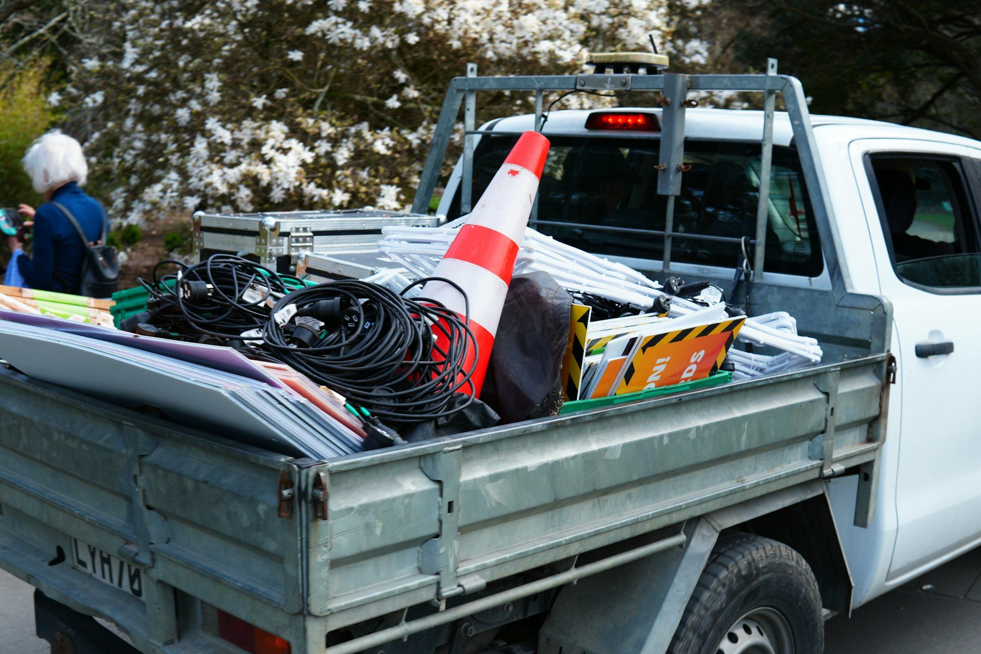 Tray of a white work ute loaded with electrical cable, a road cone and site signs in Christchurch